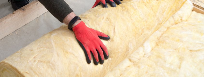 worker insulates the floor with mineral wool